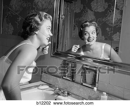 1950S Smiling Woman Looking Into Bathroom Mirror Brushing Teeth View Large Photo Image Stock Image - 1950S Smiling Woman Looking Into Bathroom Mirror Brushing Teeth . Fotosearch