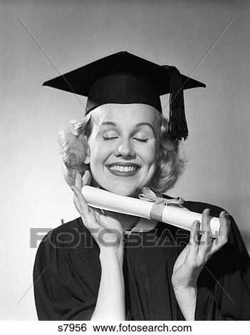 Stock Photograph - 1950S Smiling Woman Teen Girl Eyes Closed Holding Diploma Graduate Wearing Cap Gown . Fotosearch