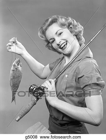 1950S Smiling Woman With A Fishing Rod Over Her Shoulder Holding Up A Fish View Large Photo Image Stock Photo - 1950S Smiling Woman With A Fishing Rod Over Her Shoulder Holding Up A Fish. Fotosearch