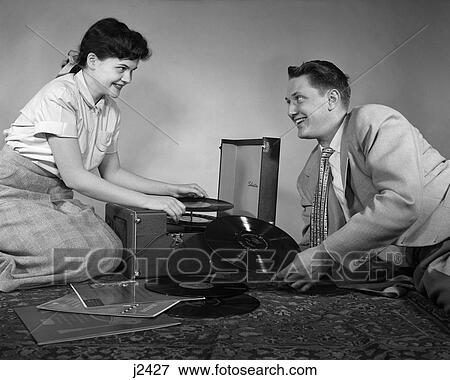 1950S Teen Couple Boy Girl Sitting Floor Playing Records On Portable Phonograph View Large Photo Image Stock Photo - 1950S Teen Couple Boy Girl Sitting Floor Playing Records On Portable Phonograph . Fotosearch