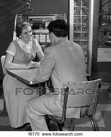 1950S Teen Couple Sits At Table In Diner Jukebox In Background Smiling Indoor View Large Photo Image Stock Image - 1950S Teen Couple Sits At Table In Diner Jukebox In Background Smiling Indoor . Fotosearch