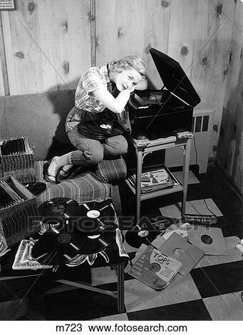 1950S Teen Girl Listening To Music On Phonograph Sit On Couch Lean On Record Player Dreaming Records 78S View Large Photo Image Stock Image - 1950S Teen Girl Listening To Music On Phonograph Sit On Couch Lean On Record Player Dreaming Records 78S . Fotosearch
