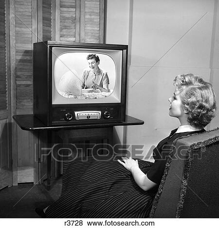 1950S Teen Sitting With Back To Viewer Watching A Woman Looking Into A Bassinet On Her Television In A Dark Room View Large Photo Image Stock Photo - 1950S Teen Sitting With Back To Viewer Watching A Woman Looking Into A Bassinet On Her Television In A Dark Room . Fotosearch