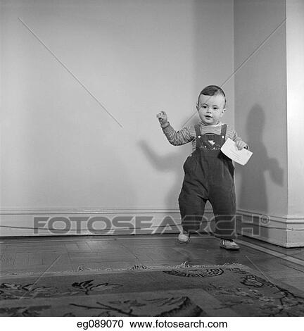 1950S Toddler Boy Standing Holding Letter About To Step On Carpet View Large Photo Image Stock Image - 1950S Toddler Boy Standing Holding Letter About To Step On Carpet . Fotosearch