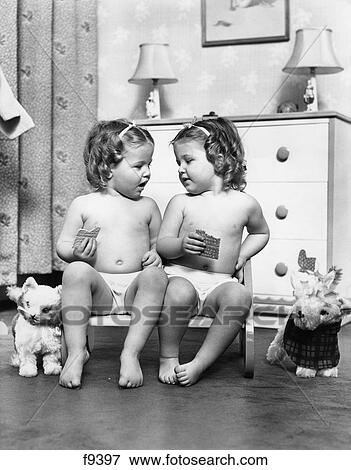 1950S Twin Girls Siting In A Double Seat Wearing Panties Only While Eating Graham Crackers View Large Photo Image Stock Photo - 1950S Twin Girls Siting In A Double Seat Wearing Panties Only While Eating Graham Crackers . Fotosearch