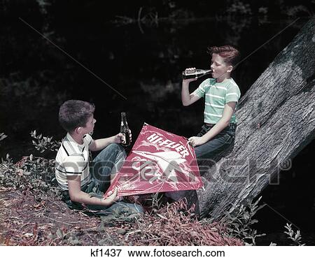 1950S Two Boys With Kite Drinking Sodas In Glass Bottles Nostalgia Pepsi Cola Soft Drinks Outdoor View Large Photo Image Stock Photo - 1950S Two Boys With Kite Drinking Sodas In Glass Bottles Nostalgia Pepsi Cola Soft Drinks Outdoor. Fotosearch