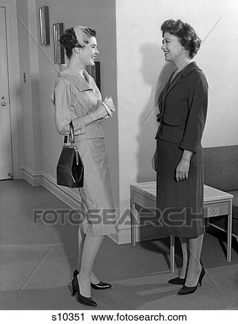 1950S Two Young Women Standing In Lobby Chatting One Wearing Feathered Hat Smiling Indoor View Large Photo Image Stock Image - 1950S Two Young Women Standing In Lobby Chatting One Wearing Feathered Hat Smiling Indoor . Fotosearch