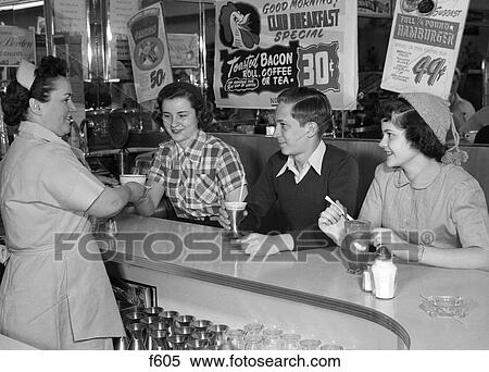 1950S Waitress Serving 2 Teen Girls And 1 Boy At Diner Counter View Large Photo Image Stock Photography - 1950S Waitress Serving 2 Teen Girls And 1 Boy At Diner Counter . Fotosearch