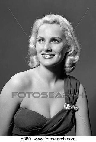 1950S Woman Portrait Wearing Asyemetric Dress With Rhinestone Clasp Looking Off Camera Smiling Indoor View Large Photo Image Stock Image - 1950S Woman Portrait Wearing Asyemetric Dress With Rhinestone Clasp Looking Off Camera Smiling Indoor . Fotosearch