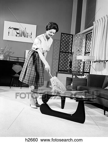 1950S Woman Wearing A White Blouse & Plaid Skirt Dusting With A Feather Duster A Glass Top Coffee Table View Large Photo Image Stock Image - 1950S Woman Wearing A White Blouse & Plaid Skirt Dusting With A Feather Duster A Glass Top Coffee Table . Fotosearch