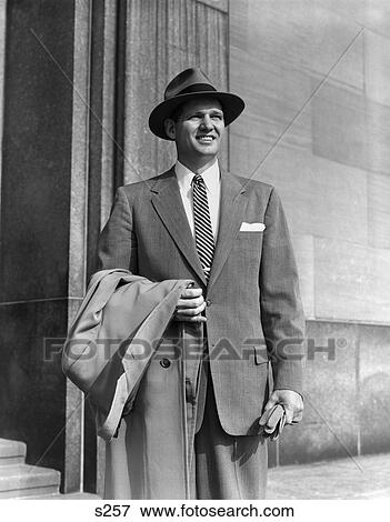 1950S Young Man In Suit And Striped Tie Wearing Hat Holding Coat Over His Arm Gloves Businessman Portrait Fashion View Large Photo Image Stock Photo - 1950S Young Man In Suit And Striped Tie Wearing Hat Holding Coat Over His Arm Gloves Businessman Portrait Fashion . Fotosearch