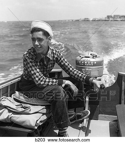 1950S Young Teen Boy Steering Boat With His Hand On Outboard Motor And His Foot On Tiller Wearing White Sailor Hat View Large Photo Image Stock Image - 1950S Young Teen Boy Steering Boat With His Hand On Outboard Motor And His Foot On Tiller Wearing White Sailor Hat . Fotosearch
