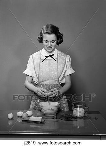 1950S Young Teen Girl Wearing Apron Braking Egg Into Mixing Bowl Cooking Baking View Large Photo Image Stock Photo - 1950S Young Teen Girl Wearing Apron Braking Egg Into Mixing Bowl Cooking Baking . Fotosearch