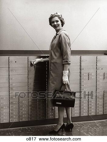 1960 1960S 1950 1950S Woman Hat Handbag Gloves About To Open Safe Safety Deposit Box Bank Banking Customer View Large Photo Image Stock Photo - 1960 1960S 1950 1950S Woman Hat Handbag Gloves About To Open Safe Safety Deposit Box Bank Banking Customer . Fotosearch