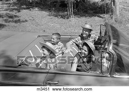 Stock Image - 1960S Family Of Four In Convertible Looking Towards Left . Fotosearch