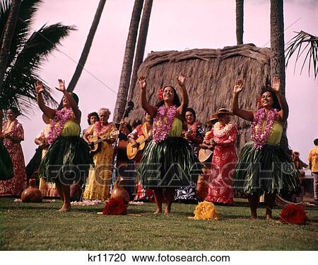 Stock Image - 1960 1960S 1970 1970S Hula Dancers Palm Thatched Shack Hawaiian Dance Dancing Tourist Attraction . Fotosearch