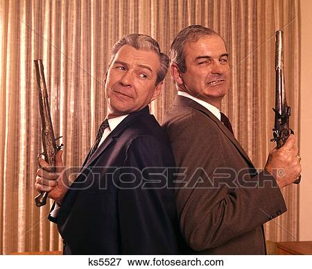 1960 1960S 2 Businessmen Back To Back Duel Duelling Pistols Disagreement Fued Problem Pistol Gun Guns Settlement View Large Photo Image Stock Photo - 1960 1960S 2 Businessmen Back To Back Duel Duelling Pistols Disagreement Fued Problem Pistol Gun Guns Settlement . Fotosearch