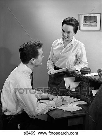 1960 1960S Couple At Desk Going Paying Bills View Large Photo Image Stock Photo - 1960 1960S Couple At Desk Going Paying Bills . Fotosearch