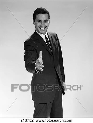 Stock Image - 1960 1960S Man In Suit Holding Hand Out To Shake Smiling . Fotosearch