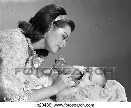 Stock Photograph - 1960 1960S Retro Mother Feeding Child . Fotosearch