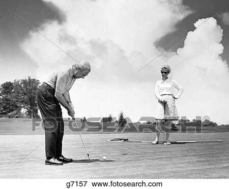 1960 1960S Retro Older Couple Putt Putting On Golfing Green View Large Photo Image Stock Photo - 1960 1960S Retro Older Couple Putt Putting On Golfing Green. Fotosearch