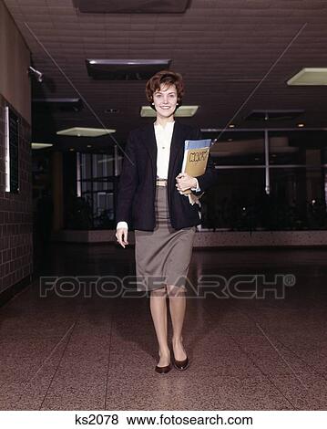 1960 1960S Smiling Girl Student Coed Walking Down Hall Carrying Books High School Teen Retro View Large Photo Image Stock Photo - 1960 1960S Smiling Girl Student Coed Walking Down Hall Carrying Books High School Teen Retro. Fotosearch