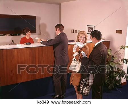 1960 1960S Three People In Line Waiting For Bank Teller Cashier View Large Photo Image Stock Photo - 1960 1960S Three People In Line Waiting For Bank Teller Cashier . Fotosearch