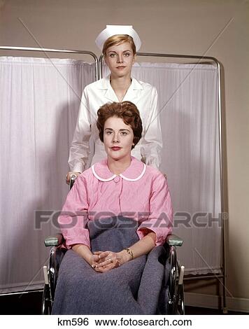 1960 1960S Woman Serious Expression In Wheelchair Female Nurse Pushing Chair Hospital Nursing Patient Medical View Large Photo Image Stock Photograph - 1960 1960S Woman Serious Expression In Wheelchair Female Nurse Pushing Chair Hospital Nursing Patient Medical . Fotosearch