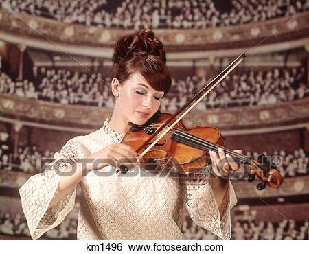 Stock Photograph - 1960 1960S Woman Violinist Playing Violin Wear White Lace Dress Audience Concert Hall Visible Background Women . Fotosearch