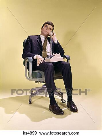 1960S 1970S Business Man In Office Chair Swivel Talking On Telphone View Large Photo Image Stock Photo - 1960S 1970S Business Man In Office Chair Swivel Talking On Telphone . Fotosearch