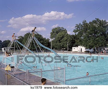 1960S 1970S Community Public Or Country Club Swimming Pool With 2 Water Slides Lifeguard Recreation Summer Fun View Large Photo Image Stock Photo - 1960S 1970S Community Public Or Country Club Swimming Pool With 2 Water Slides Lifeguard Recreation Summer Fun. Fotosearch