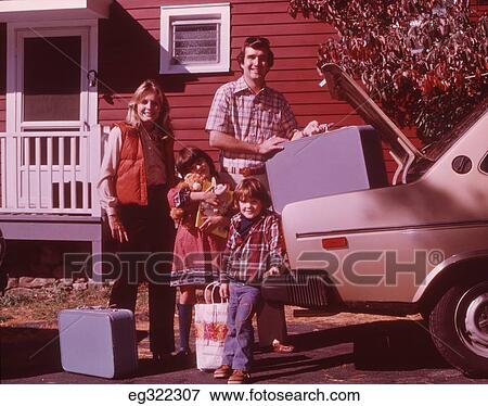 1960S 1970S Family In Front Of House Loading Car For Vacation View Large Photo Image Stock Photo - 1960S 1970S Family In Front Of House Loading Car For Vacation . Fotosearch
