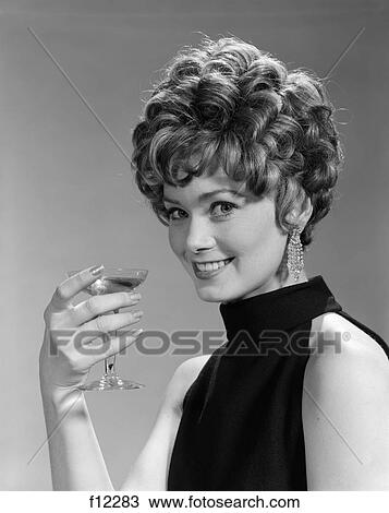 1960S 1970S Glamourous Woman With Curly Hair And Dangling Earrings Smiling Holding A Champagne Glass View Large Photo Image Stock Image - 1960S 1970S Glamourous Woman With Curly Hair And Dangling Earrings Smiling Holding A Champagne Glass . Fotosearch