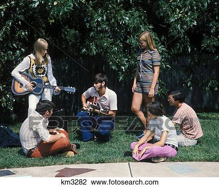 1960S 1970S Group Of 6 Teens Boys Girls In Backyard Summer 1 Boy 1 Girl Playing Guitar Sideburns Fashion View Large Photo Image Stock Image - 1960S 1970S Group Of 6 Teens Boys Girls In Backyard Summer 1 Boy 1 Girl Playing Guitar Sideburns Fashion. Fotosearch