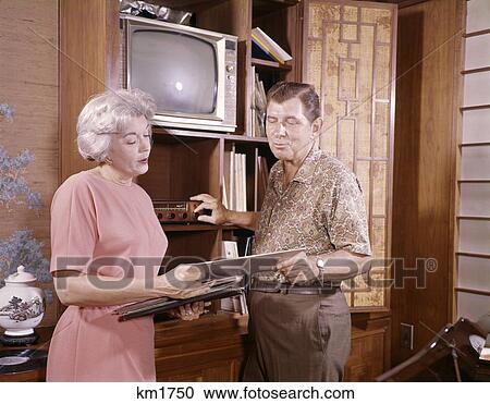 1960S 1970S Mature Couple Man And Woman Playing 33 Rpm Phonograph Records At Home Entertainment Center View Large Photo Image Stock Image - 1960S 1970S Mature Couple Man And Woman Playing 33 Rpm Phonograph Records At Home Entertainment Center. Fotosearch