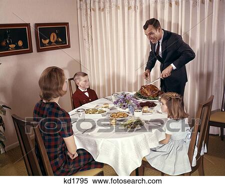 1960S 1970S Mother, Son And Daughter Sitting At Table Watching Father Carve Chicken Indoor Man Woman Boy Girl View Large Photo Image Stock Photography - 1960S 1970S Mother, Son And Daughter Sitting At Table Watching Father Carve Chicken Indoor Man Woman Boy Girl . Fotosearch