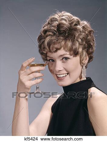1960S 1970S Portrait Glamour Woman In Black Dress Earrings Holding A Cocktail View Large Photo Image Picture - 1960S 1970S Portrait Glamour Woman In Black Dress Earrings Holding A Cocktail. Fotosearch