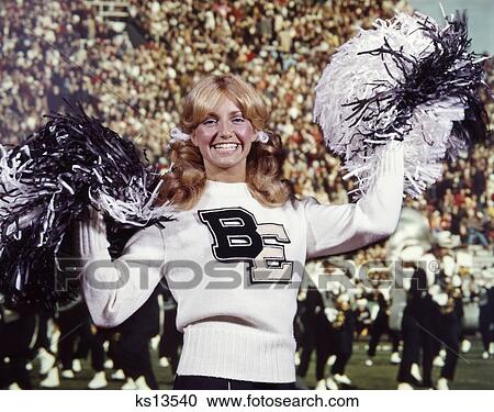 1960S 1970S Smiling Blonde Cheerleader Woman Black & White Sweater Uniform Pompoms At Football Game Marching Band View Large Photo Image Stock Image - 1960S 1970S Smiling Blonde Cheerleader Woman Black & White Sweater Uniform Pompoms At Football Game Marching Band. Fotosearch