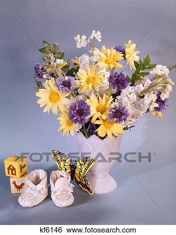 Stock Photograph - 1960S 1970S Spring Bouquet Flowers Vase Baby Booties Toy Blocks Butterfly Yellow Daisies Purple White Flowers . Fotosearch