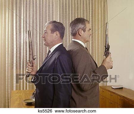 1960S 2 Middle Aged Business Men Stand Back To Back Holding Guns Duel Pistols View Large Photo Image Stock Photograph - 1960S 2 Middle Aged Business Men Stand Back To Back Holding Guns Duel Pistols . Fotosearch