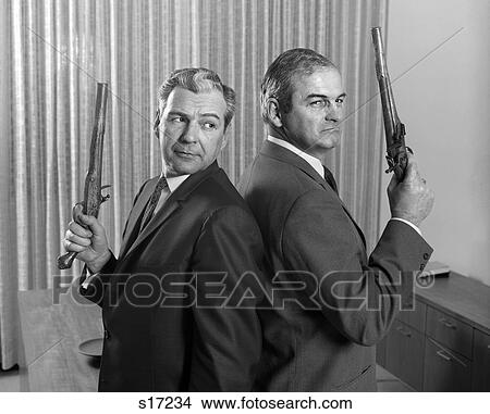 1960S 2 Middle Aged Men Back To Back Holding Duel Pistols Guns View Large Photo Image Picture - 1960S 2 Middle Aged Men Back To Back Holding Duel Pistols Guns . Fotosearch