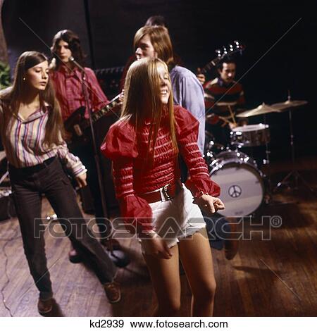 1960S 2 Teenage Girls & Teen Boy Dance Dancing In Front Of Rock & Roll Band Hot Pants Fashion Peace Sign On Drum Music View Large Photo Image Stock Photo - 1960S 2 Teenage Girls & Teen Boy Dance Dancing In Front Of Rock & Roll Band Hot Pants Fashion Peace Sign On Drum Music. Fotosearch