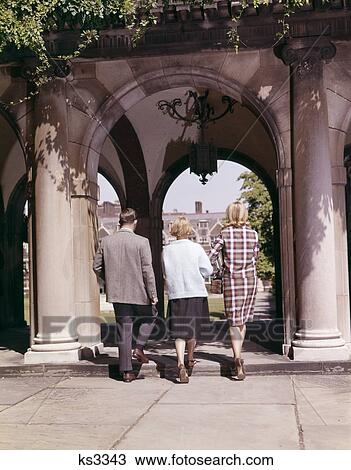 1960S 3 College Students Boy 2 Girls Walking Under Ivy Covered Arch Campus Education University League Retro View Large Photo Image Stock Image - 1960S 3 College Students Boy 2 Girls Walking Under Ivy Covered Arch Campus Education University League Retro . Fotosearch