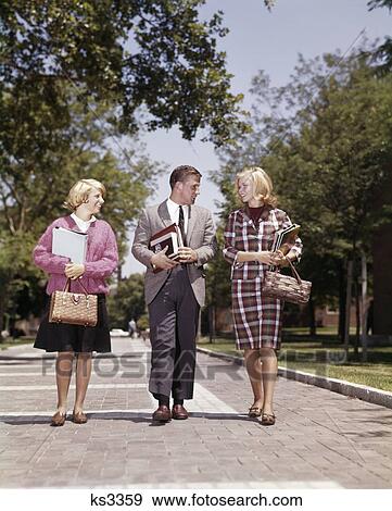 1960S 3 Students Walking On Campus Carry Books Boy In Suit & Tie 2 Blonde Girls Straw Hand Bags Fashion Brick Sidewalk View Large Photo Image Stock Photo - 1960S 3 Students Walking On Campus Carry Books Boy In Suit & Tie 2 Blonde Girls Straw Hand Bags Fashion Brick Sidewalk. Fotosearch