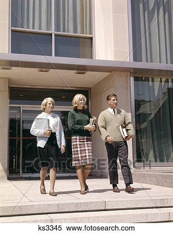 1960S 3 Teenagers Carrying Textbooks Walking Out Of School Building High School Or University View Large Photo Image Stock Photography - 1960S 3 Teenagers Carrying Textbooks Walking Out Of School Building High School Or University . Fotosearch