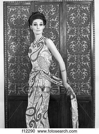 1960S 3/4 Length Portrait Of A Woman Posing In Front Of Dressing Screen Wearing Paisley Gown & Strings Of Beads View Large Photo Image Stock Image - 1960S 3/4 Length Portrait Of A Woman Posing In Front Of Dressing Screen Wearing Paisley Gown & Strings Of Beads . Fotosearch