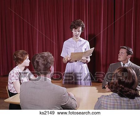 1960S 5 Students Teens Around Table Red Curtain One Girl Standing Open Folder Giving Speech Report Retro Vintage View Large Photo Image Stock Photo - 1960S 5 Students Teens Around Table Red Curtain One Girl Standing Open Folder Giving Speech Report Retro Vintage. Fotosearch