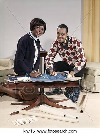 1960S African-American Couple In Living Room Looking At Blueprints For New Home Man Woman Plan Indoor View Large Photo Image Stock Photography - 1960S African-American Couple In Living Room Looking At Blueprints For New Home Man Woman Plan Indoor. Fotosearch