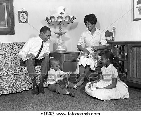 Stock Image -  1960S African-American Family 4 Living Room Father Sitting Couch Mother Chair Boy Girl Kid . Fotosearch