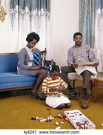 1960S African-American Family Mother Father Sitting Reading Living Room Girl Daughter Playing Floor Toys Lego Retro View Large Photo Image Stock Image - 1960S African-American Family Mother Father Sitting Reading Living Room Girl Daughter Playing Floor Toys Lego Retro . Fotosearch